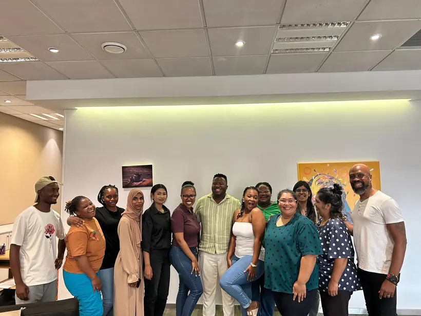 A smiling cohort of course participants photographed together after a training session