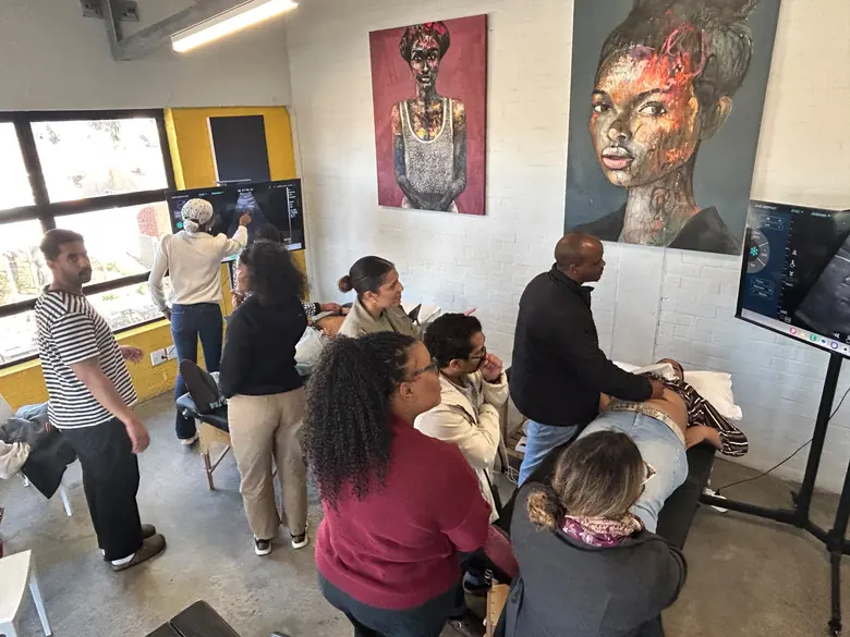 Participants practising ultrasound scanning at multiple stations during a hands-on workshop